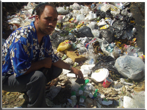 Pastor Pablo Urena standing over medical waste at the Santiago Trash Dump
